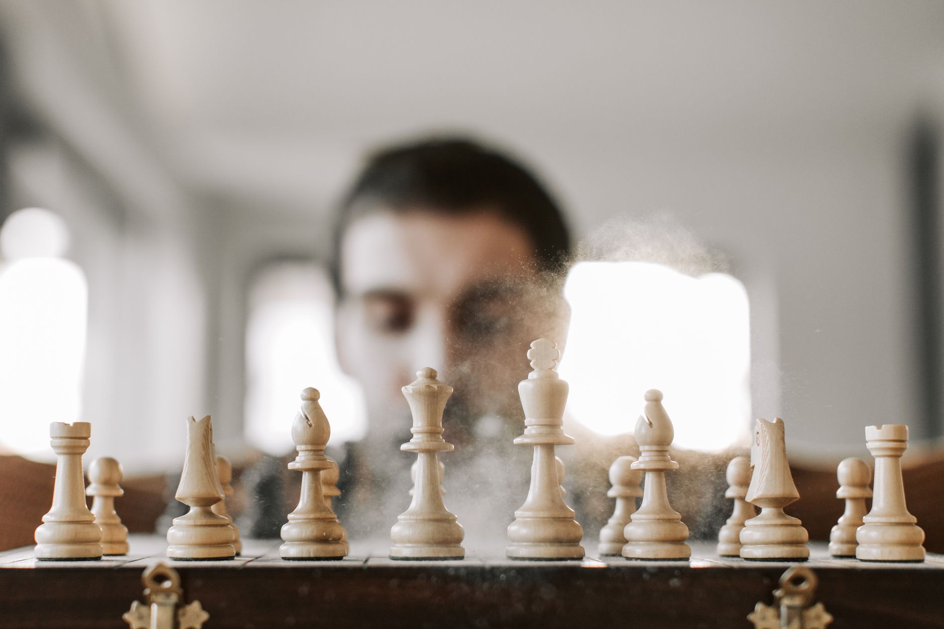 Close-up of a chessboard with chess pieces in action, representing strategy and concentration.