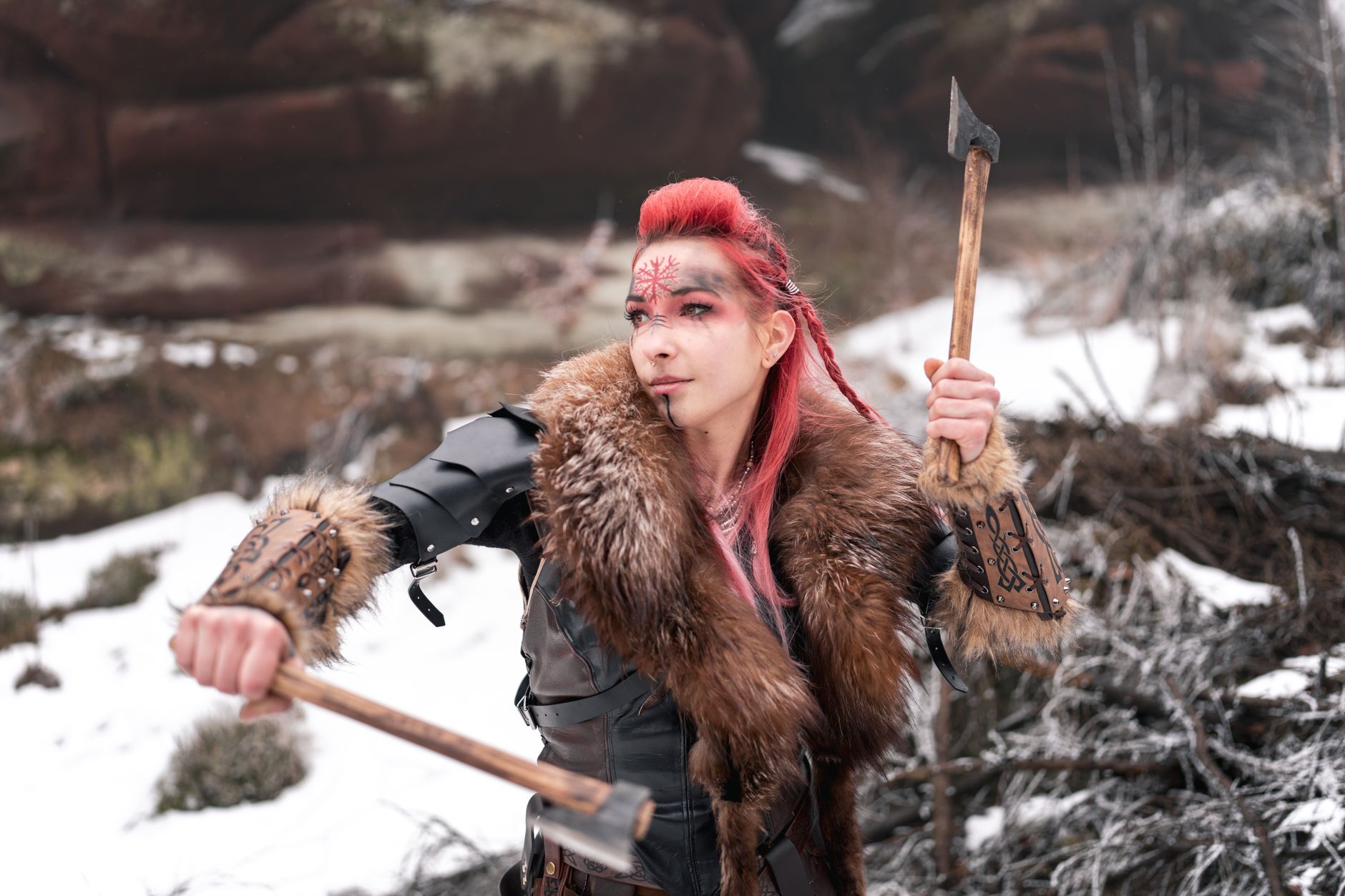 Viking woman in winter armor holding axes, ready for battle; fierce and determined.