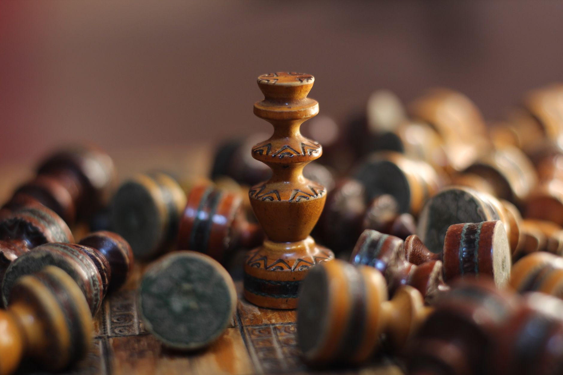 Detailed view of wooden chess pieces, focusing on central piece on a chessboard.