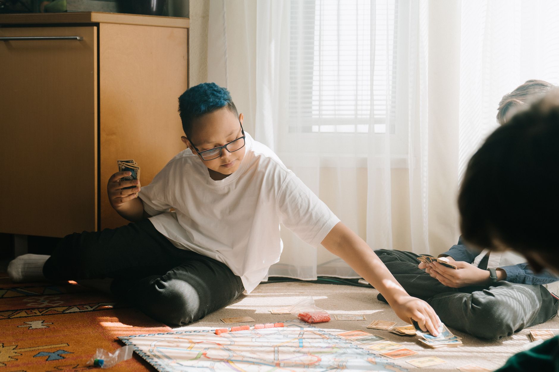 A group of children playing a strategic board game indoors, fostering teamwork and fun.