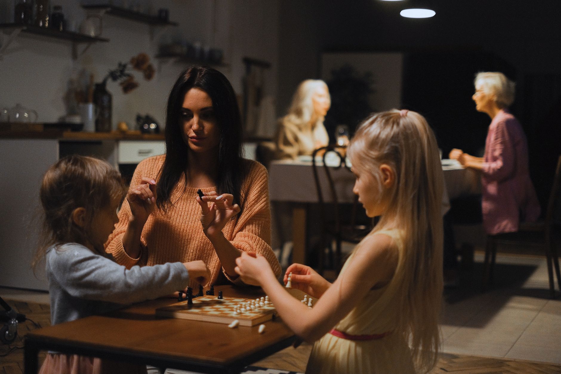 A family enjoys quality time playing chess together, fostering bonding and strategic thinking.