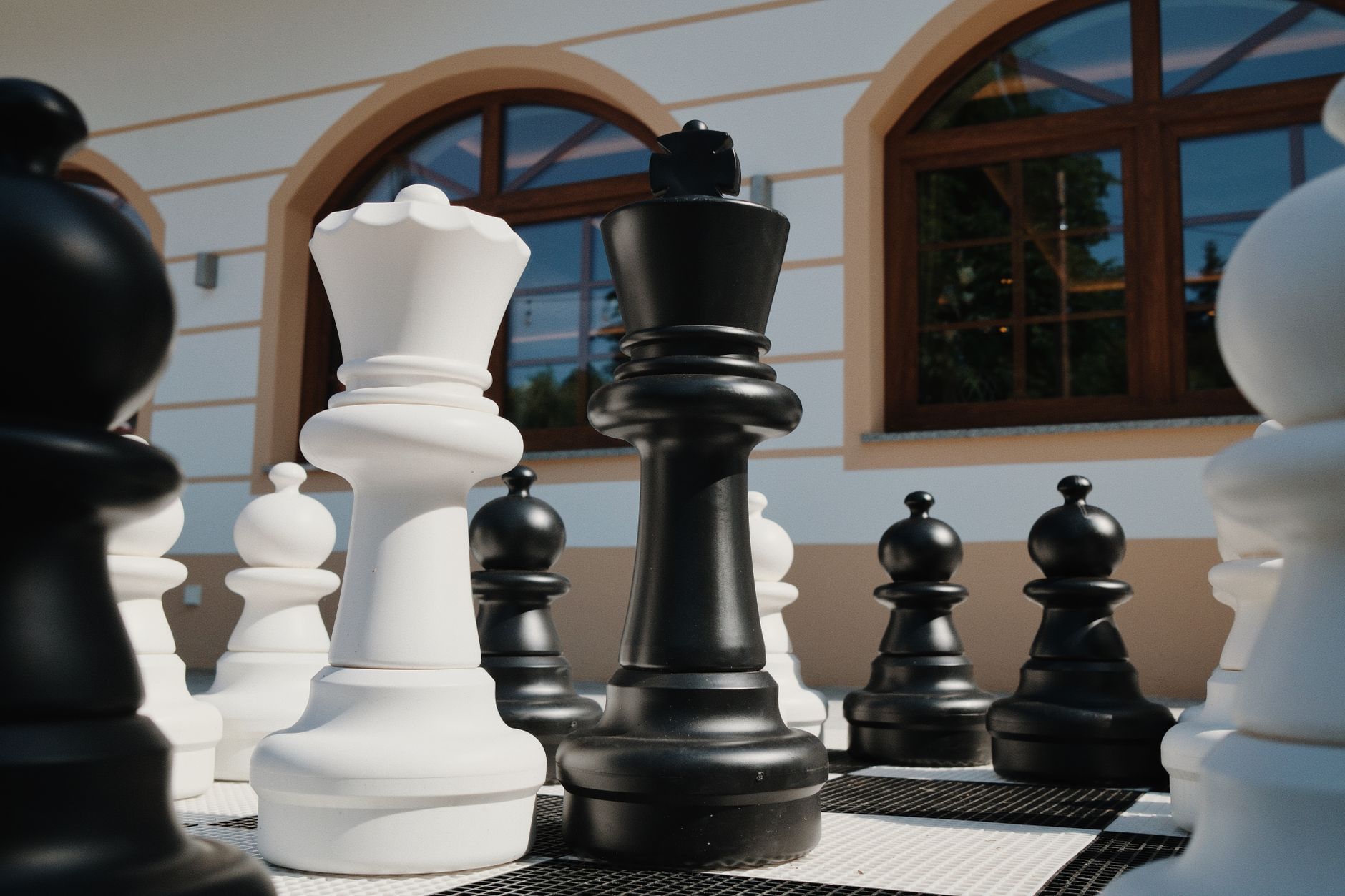 Close-up of giant chess pieces outdoors. Sunlit strategy game for outdoor leisure.