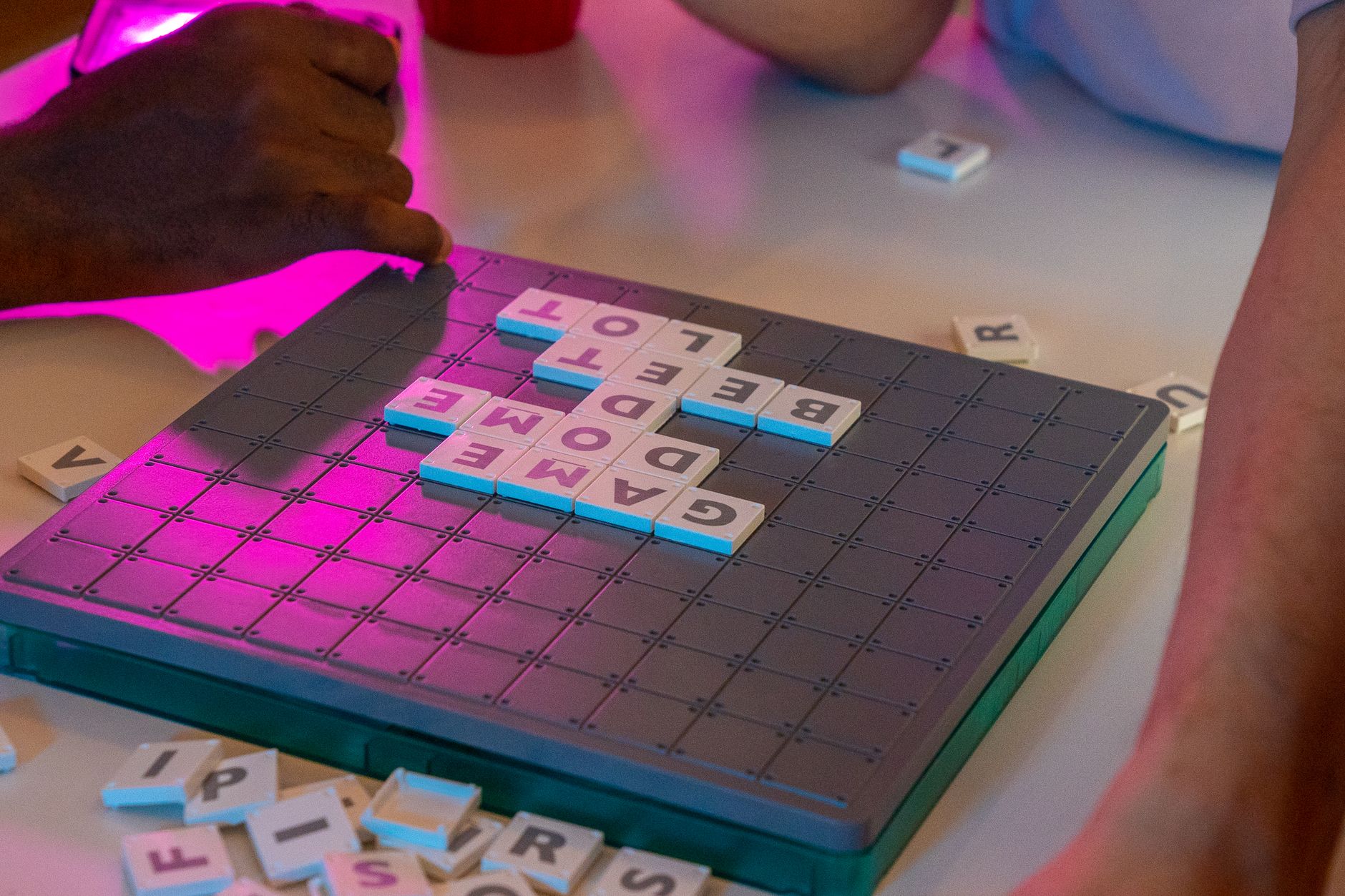 Enjoy an exciting board game night with friends creating words with letter tiles. Perfect leisure activity.