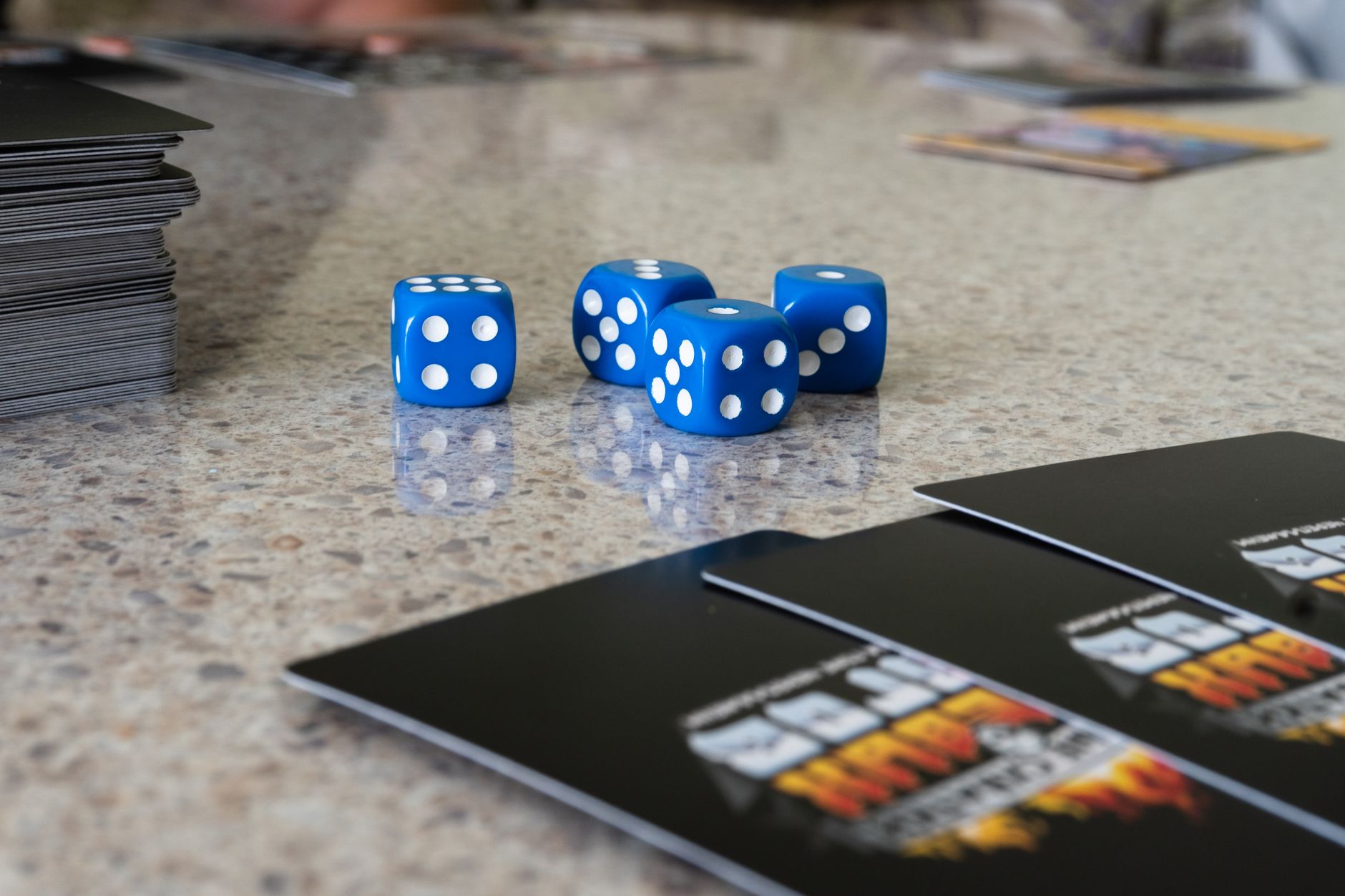 Blue dice and game cards on a table surface, ideal for gaming and strategy concepts.
