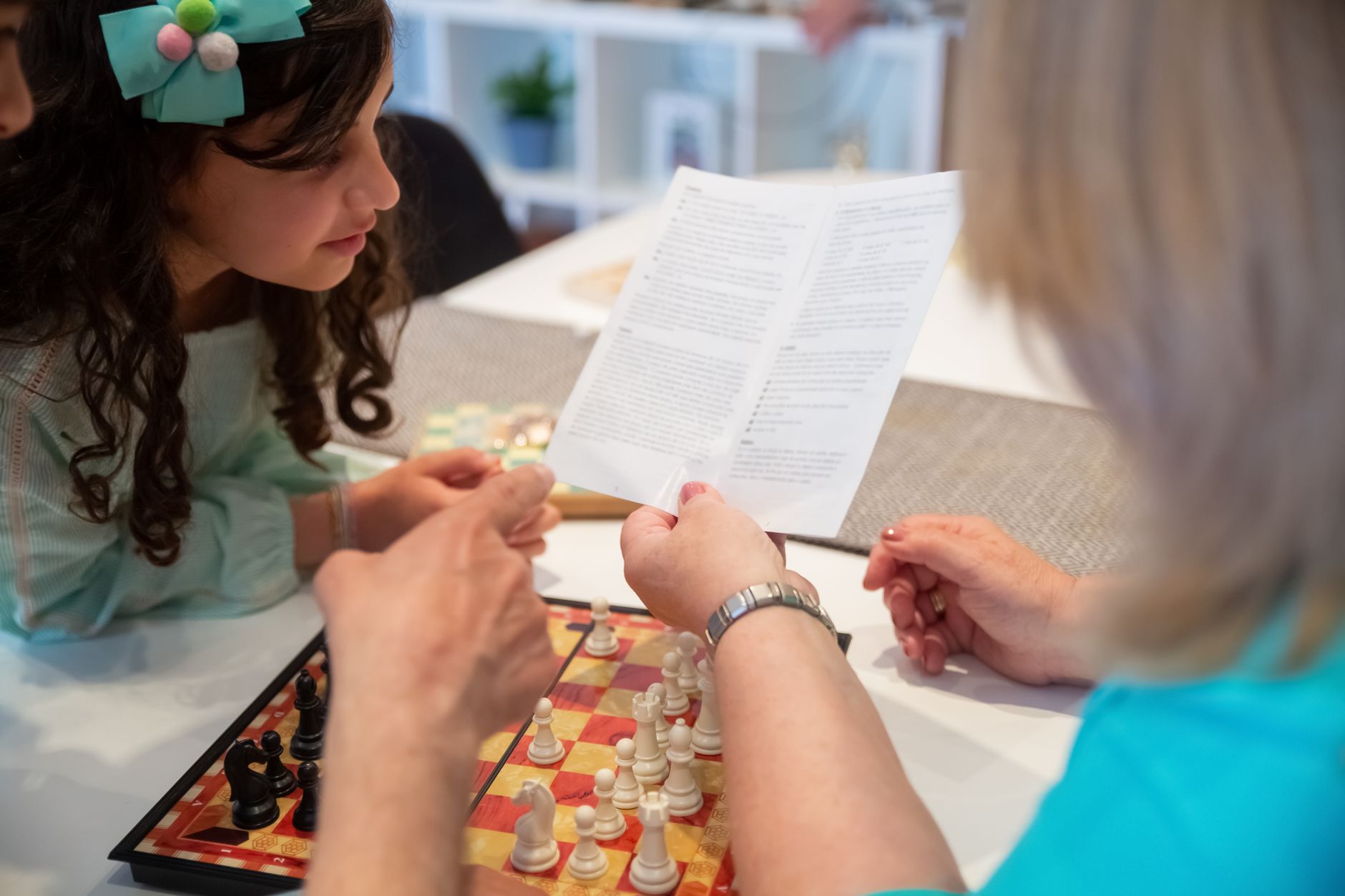 A family learning chess rules together, encouraging bonding and strategy skills.