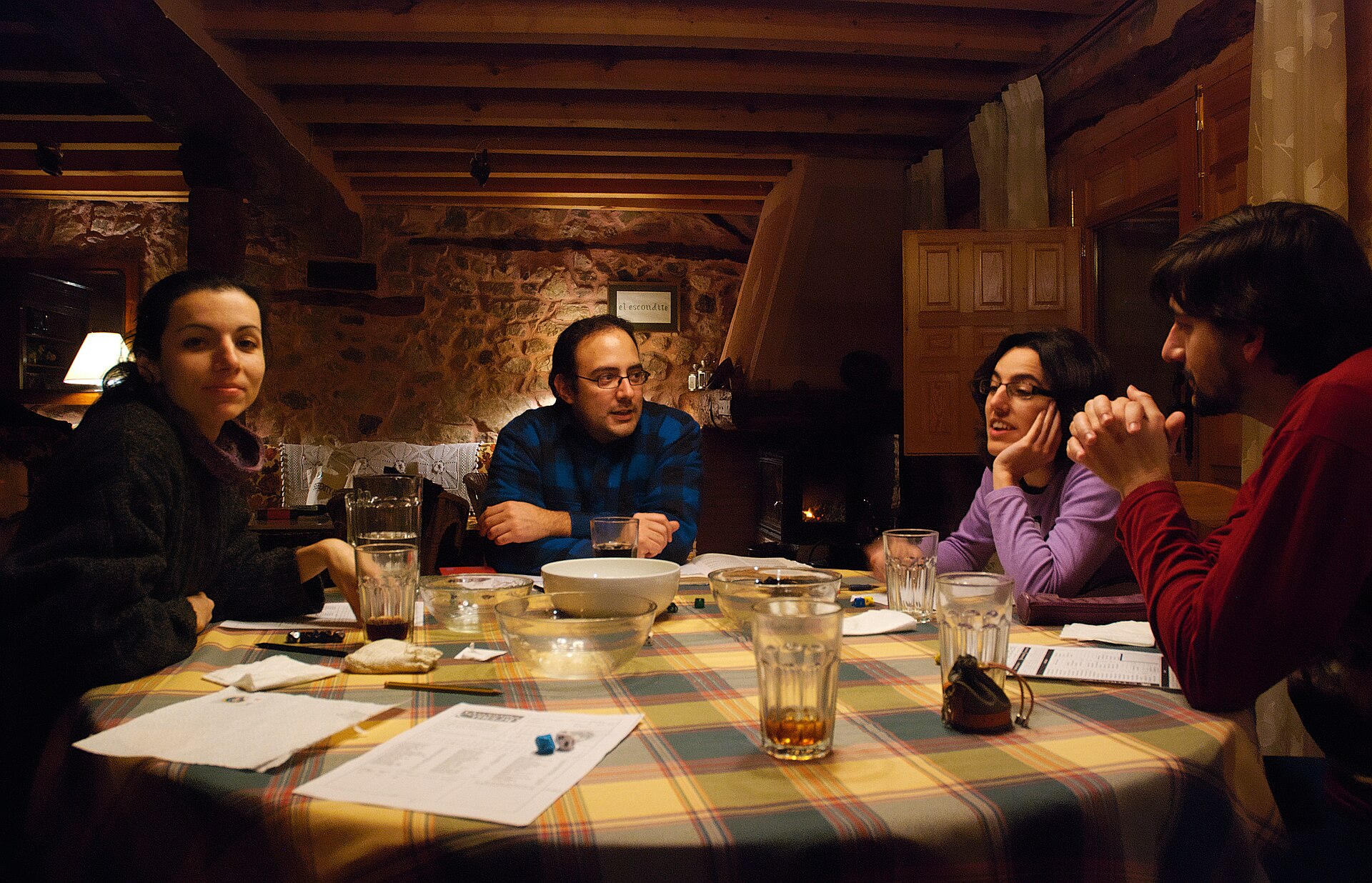 A group of role playing gamers, enjoying a night session. Dice, snacks, beverages, character sheets and a comfortable countryside house comb