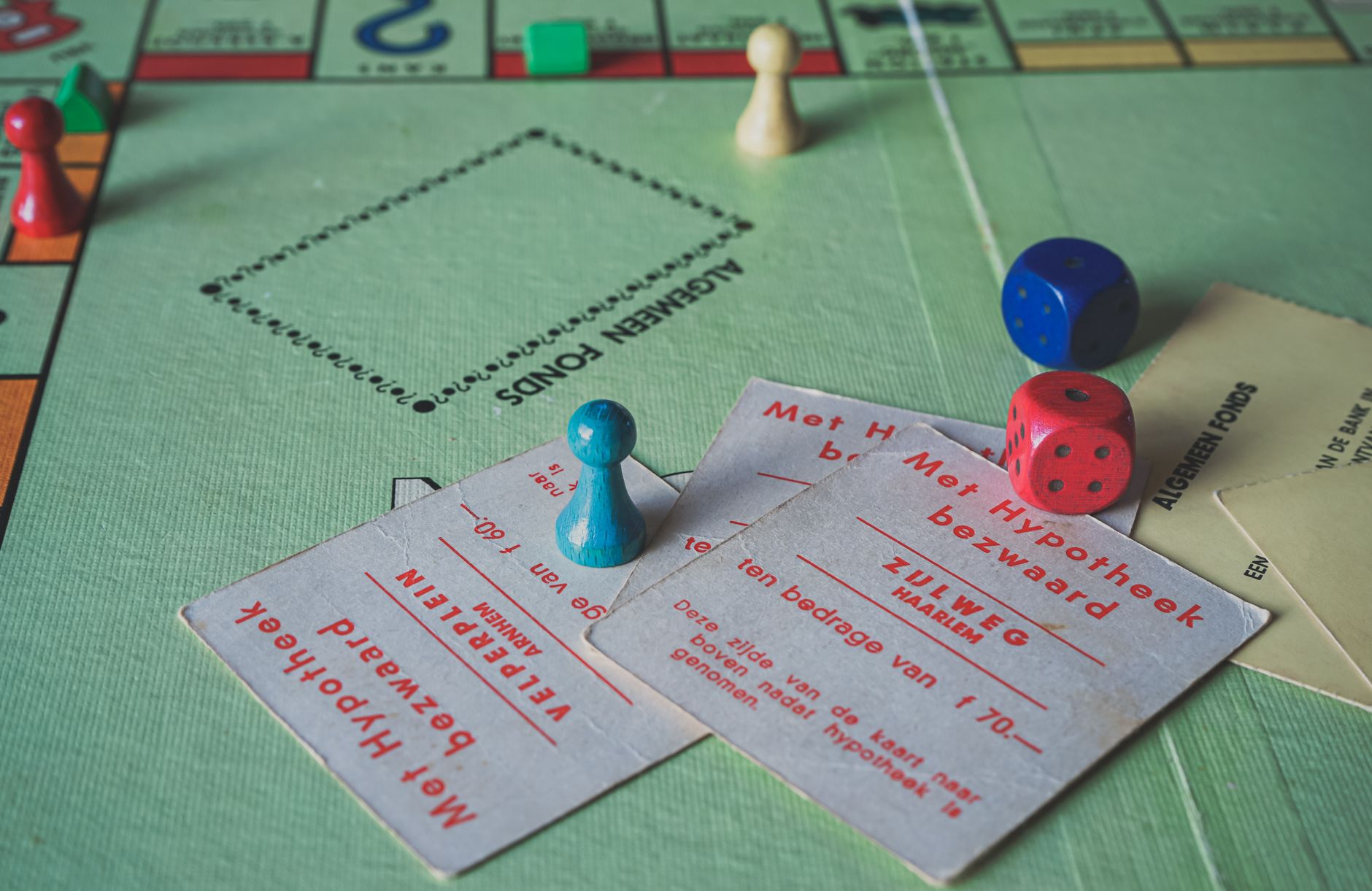 Close-up of vintage Monopoly game pieces and cards on a game board.
