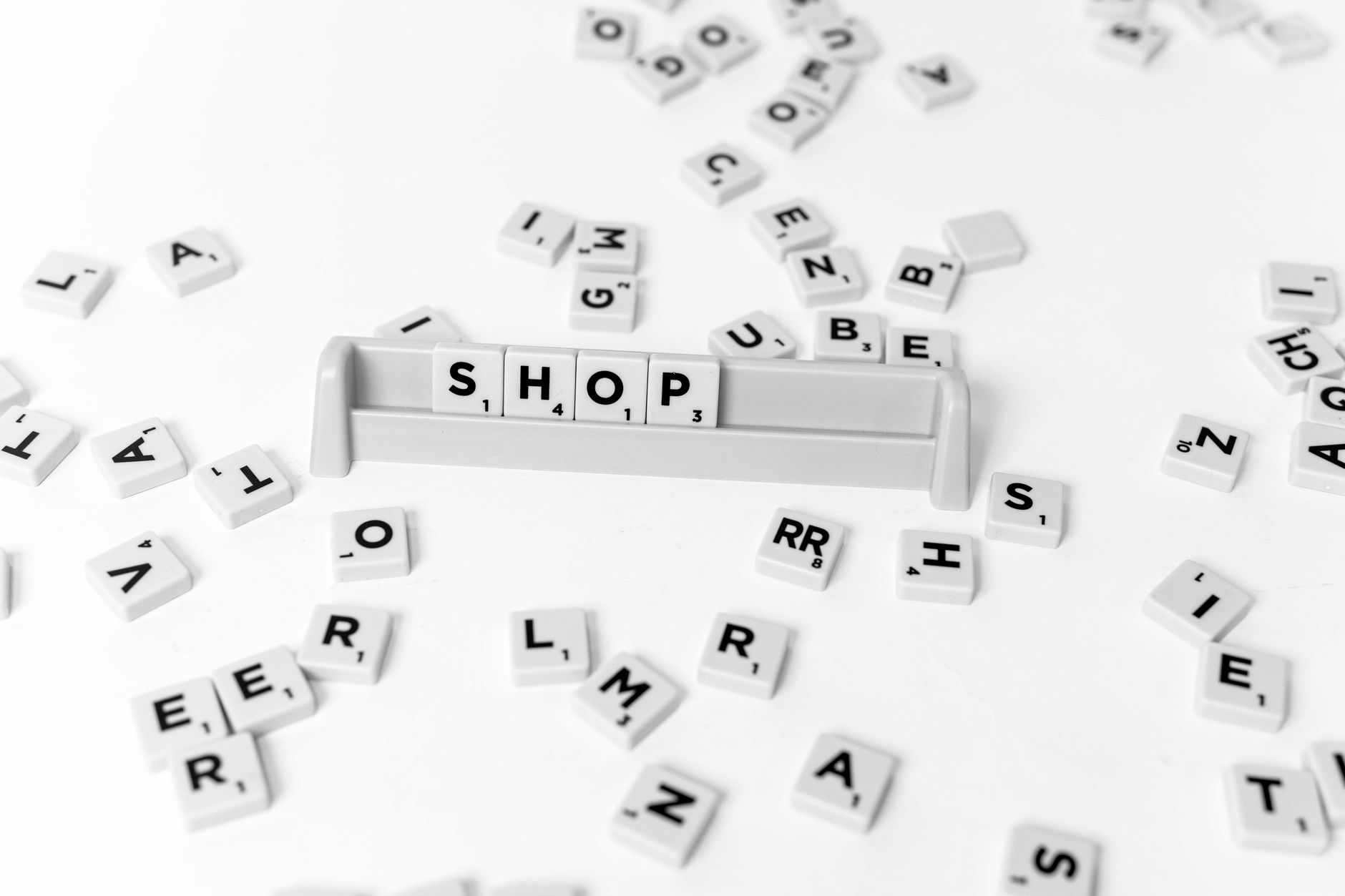 Scrabble tiles forming the word 'shop' on a white background, perfect for business themes.