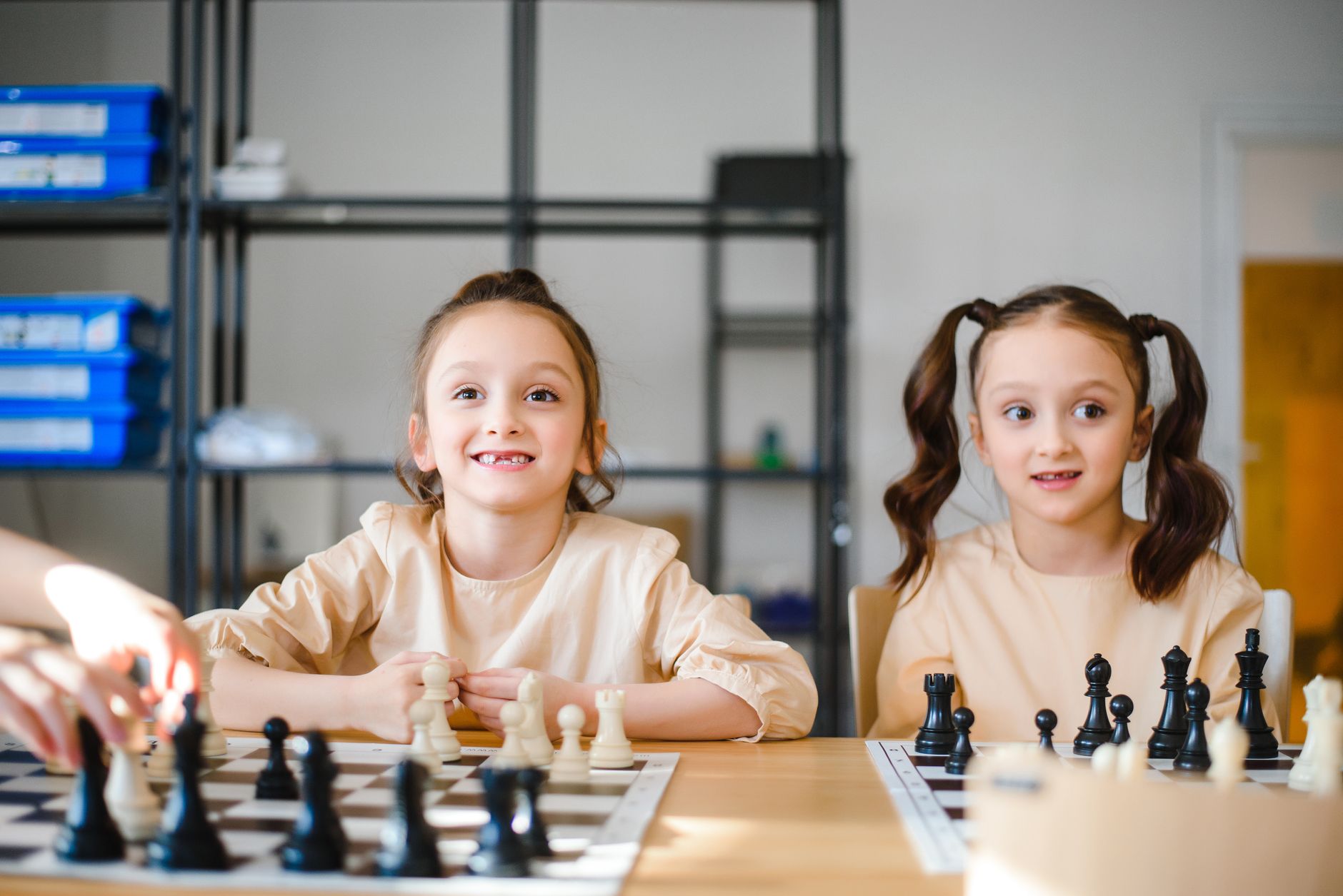 Two young girls enjoy a game of chess, focusing on strategy and fun.