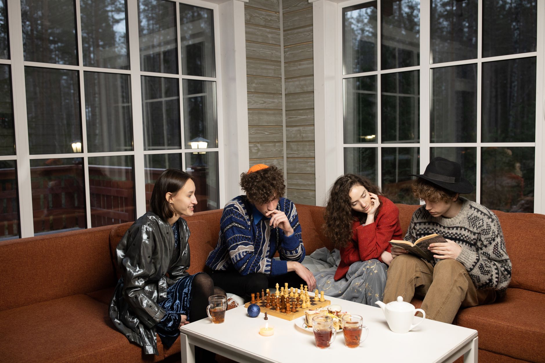 A group of young friends celebrating Hanukkah indoors with games and drinks, sharing a moment of togetherness.